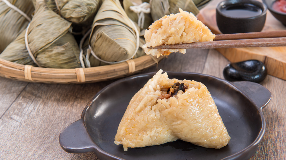 Zongzi on cast iron plate picked up with chopsticks