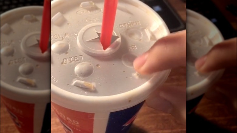 person pushing cup button lid