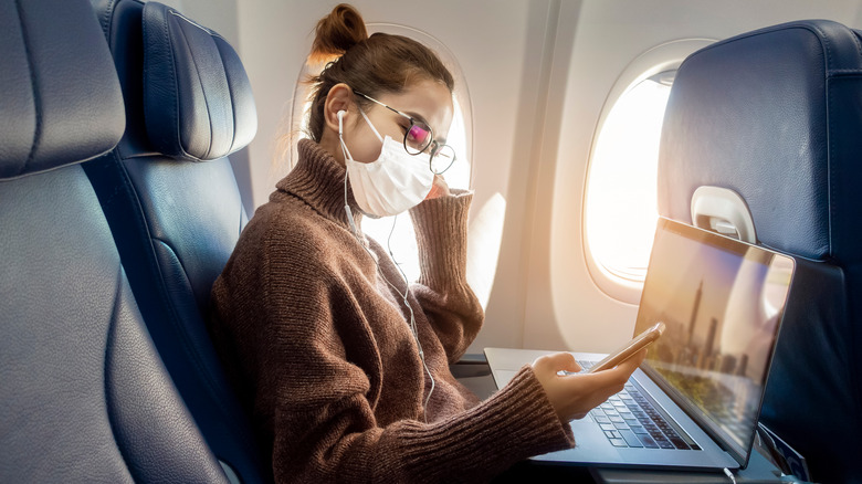 Passenger flying on airplane with mask