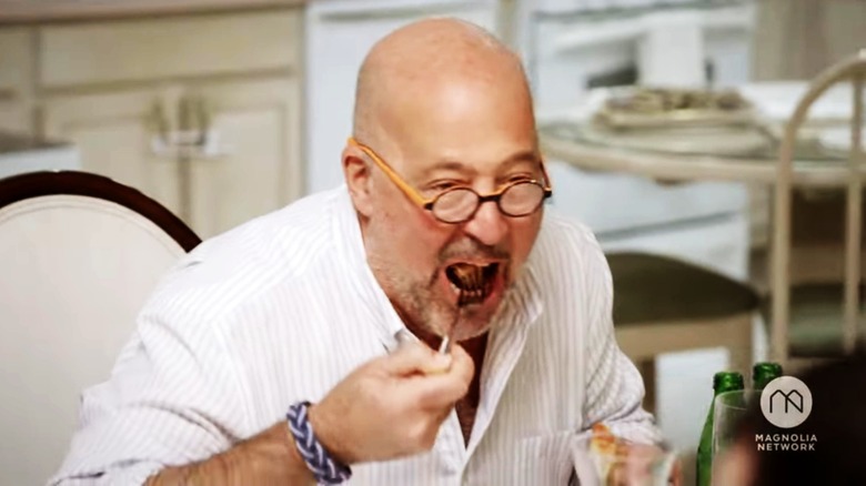 Andrew Zimmern taking a bite