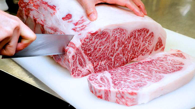 Butcher cutting raw kobe beef