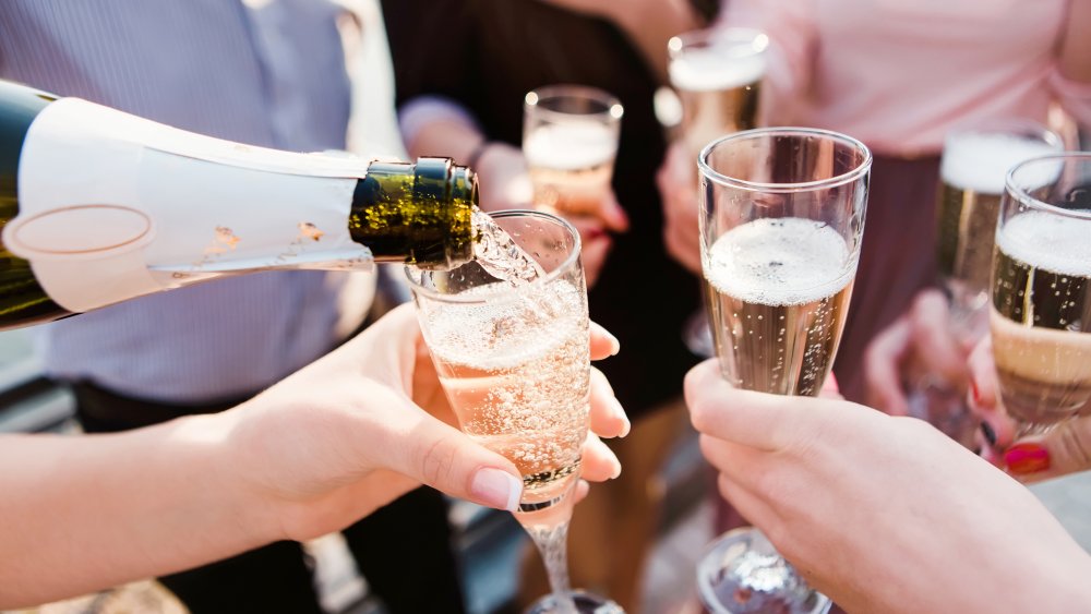 Champagne glasses in partiers' hands