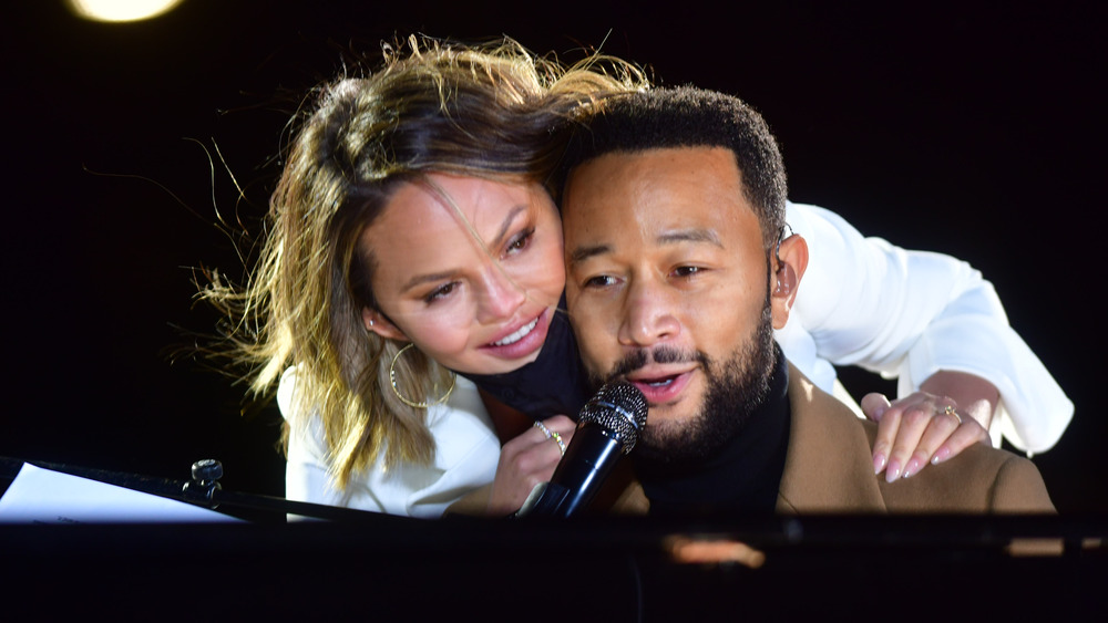 John Legend and Chrissy Teigen being cute together while John Legend performs for a Democratic rally in the 2020 election campaign.