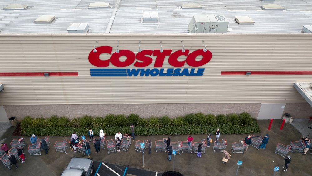 Customers wait outside a Costco 