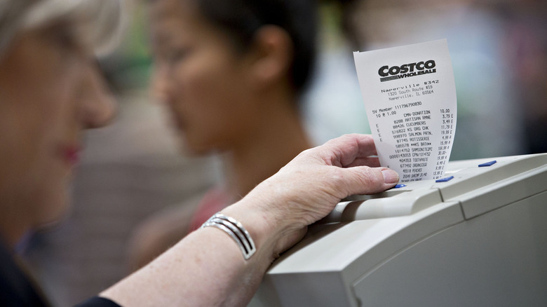 woman taking Costco receipt out of printer