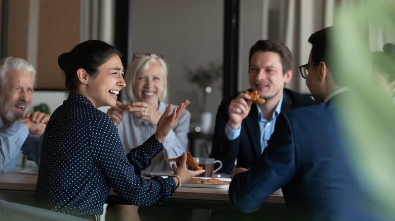 Office workers eating pizza