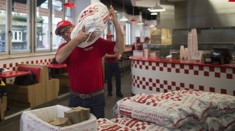 Five Guys employee carries potatoes 