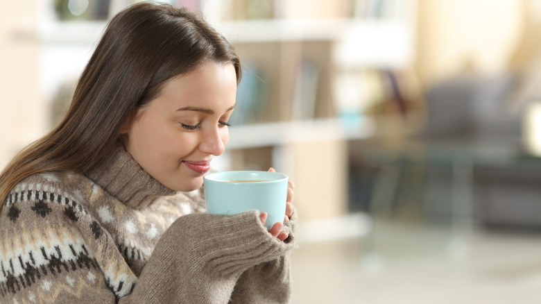 woman smelling hot drink