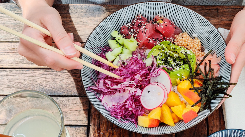 Using chopsticks to eat poke