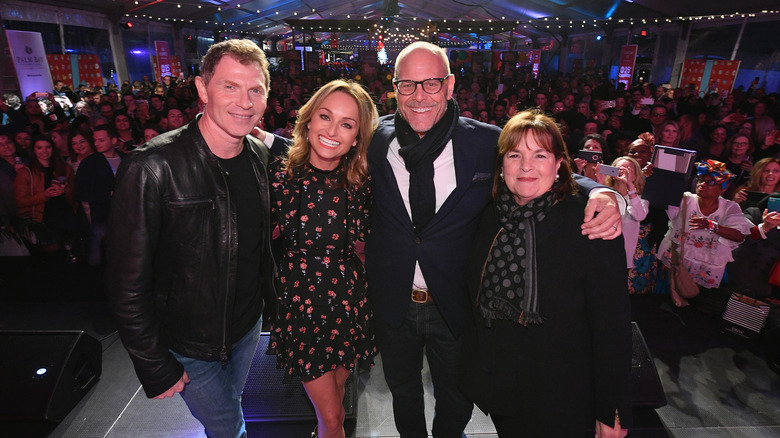 Ina Garten stands with Bobby Flay, Giada De Laurentiis, and Alton Brown in front of audience