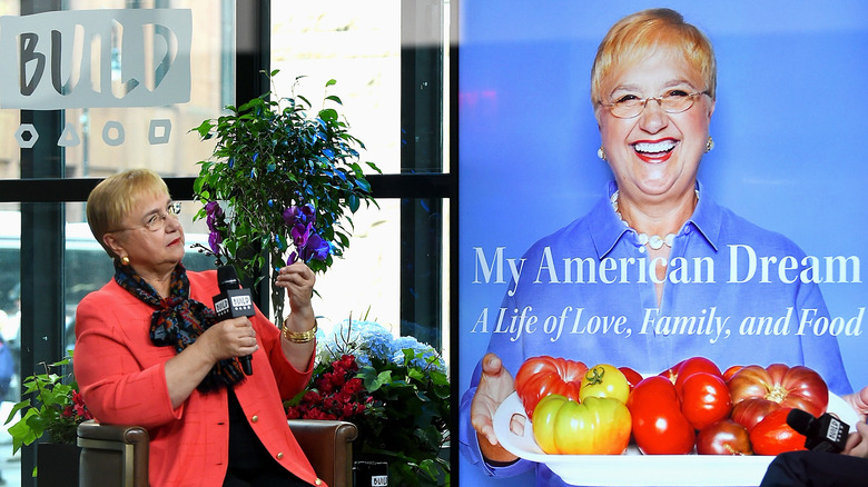 Lidia Bastianich stand nexts to cover of book