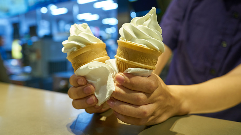 Worker handing a customer McDonald's soft serve cones