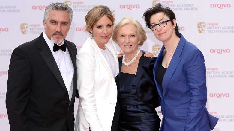 Paul Hollywood, Mary Berry, Sue Perkins, and Mel Giedroyc smile with arms around each other