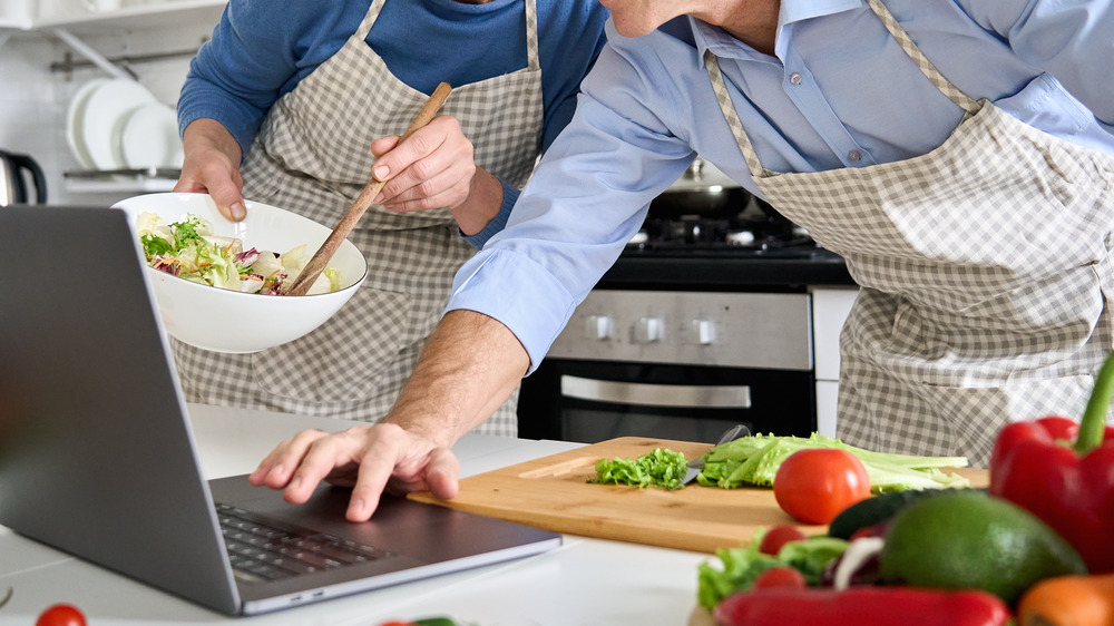 Couple cooking with online recipe