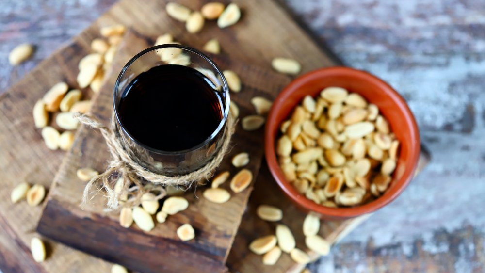 glass of coke with a bowl of peanuts next to it