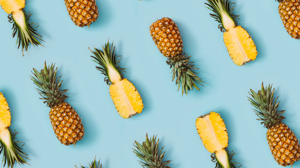 Halved pineapples on blue background