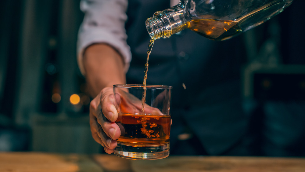 Man pouring Scotch into glass