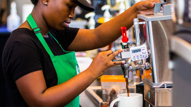 Starbucks barista making coffee in a white cup