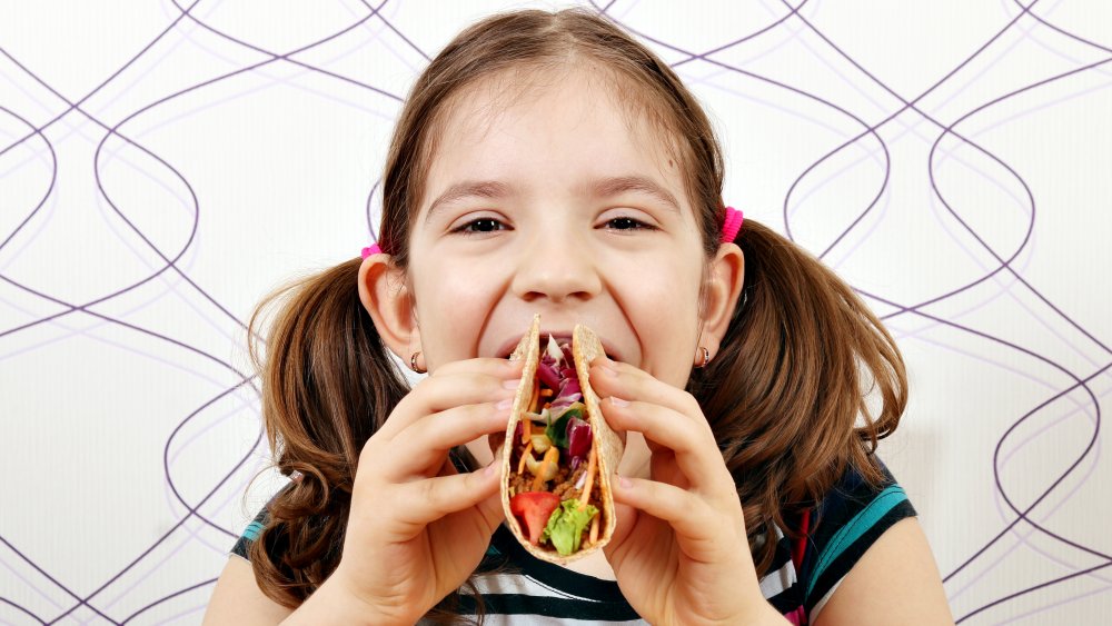 girl eating taco