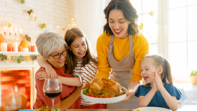 Woman serving Thanksgiving turkey to family