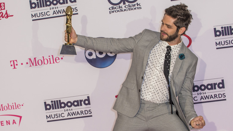 Thomas Rhett holding an award