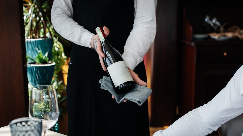 Sommelier holding wine bottle