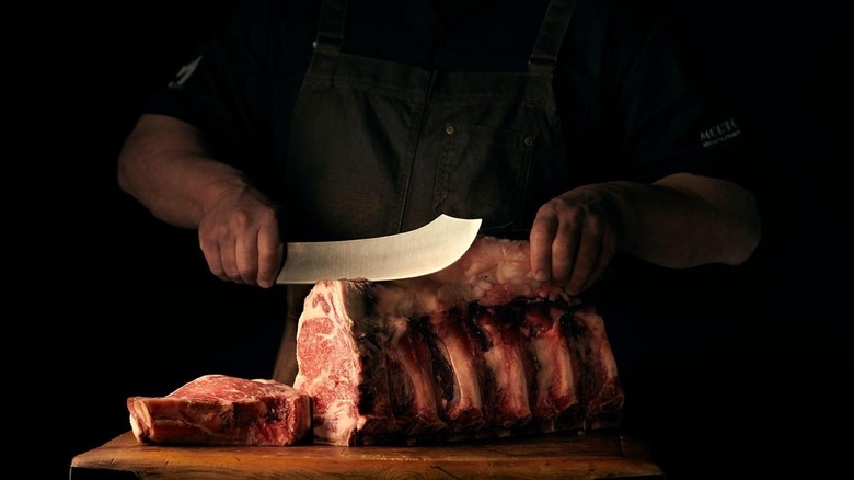 Man carving steaks with knife