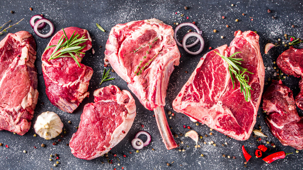 Steaks on a black background with garnishes