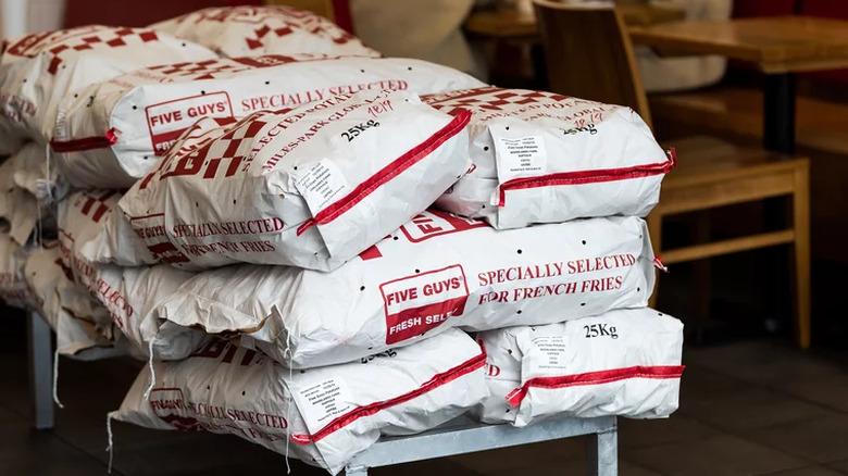 A stack of Five Guys-branded potato-filled sacks