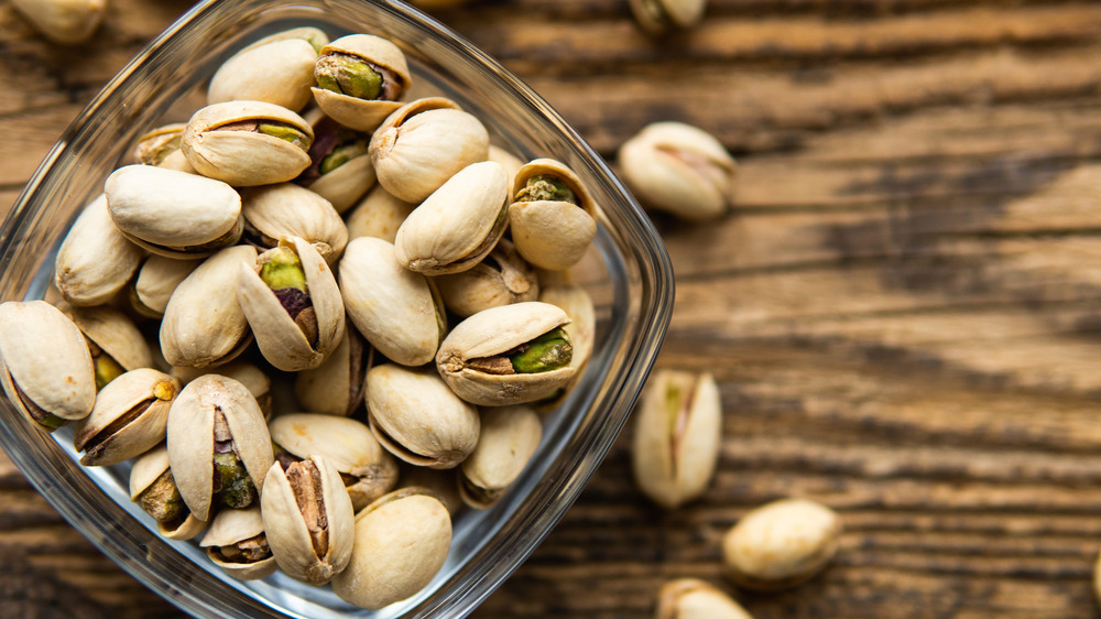 Pistachios in a glass bowl on a wooden table