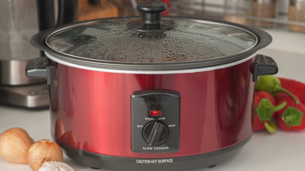 Red slow cooker on the kitchen counter