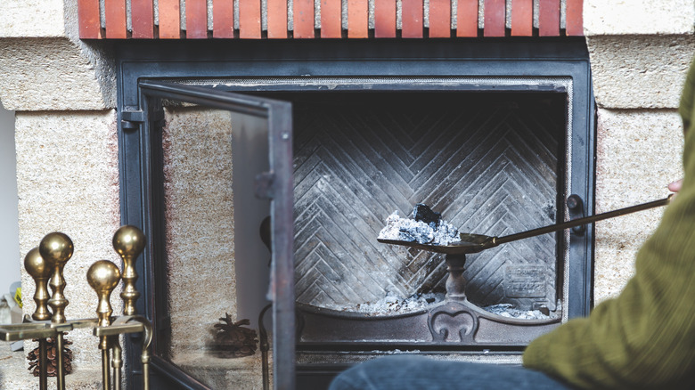 man cleaning fireplace