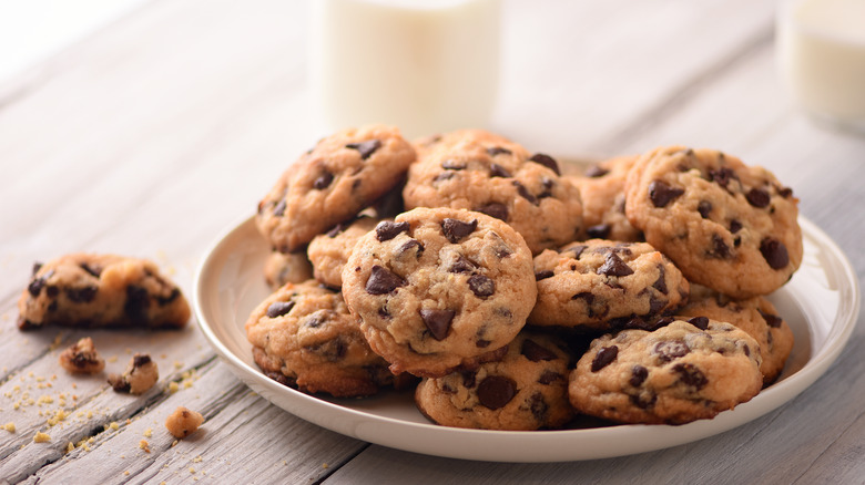 Full plate of chocolate chip cookies with glass of milk