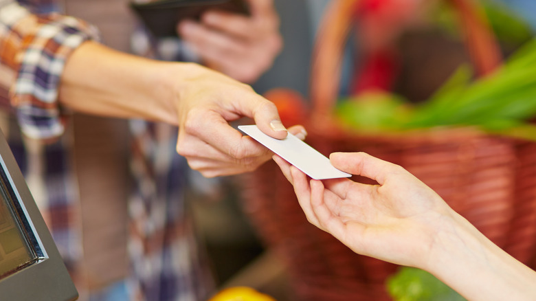 A customer hands a credit card at checkout