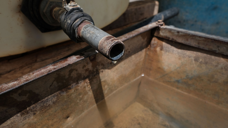 Rusted tap with drop of water