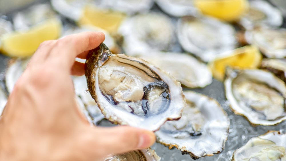 man grabbing an oyster