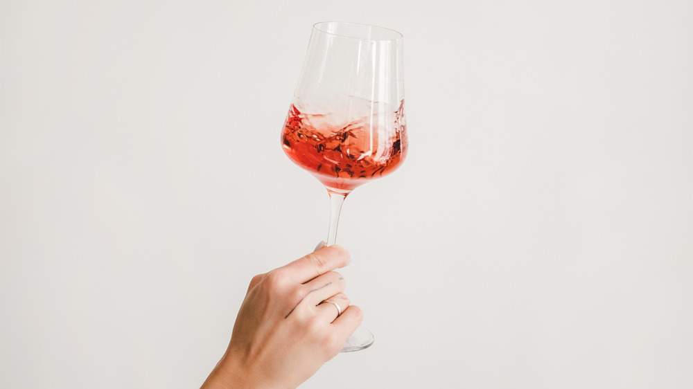 hand holding glass of rosé wine