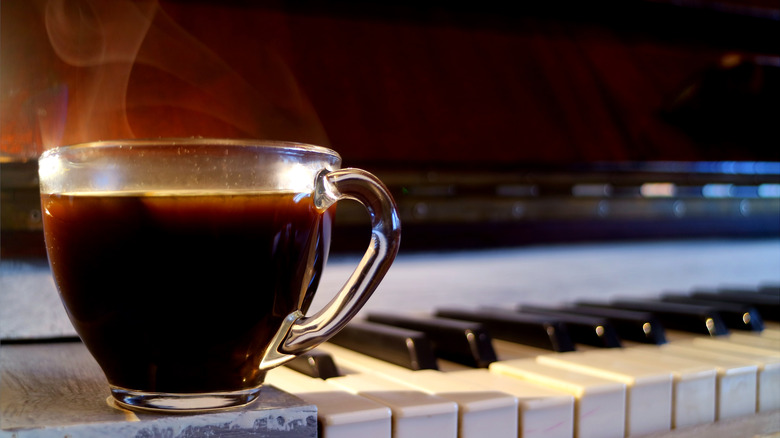 Cup of black coffee on piano