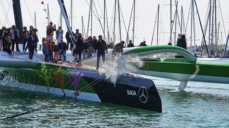  People watching man break champagne on boat