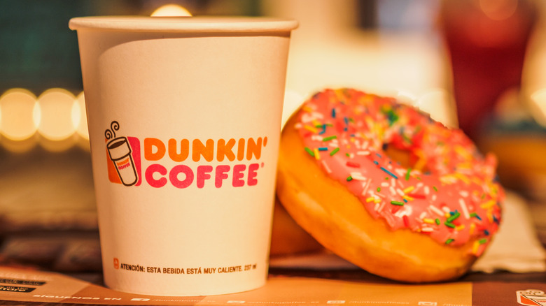 Dunkin' black coffee in a paper cup and chocolate donut