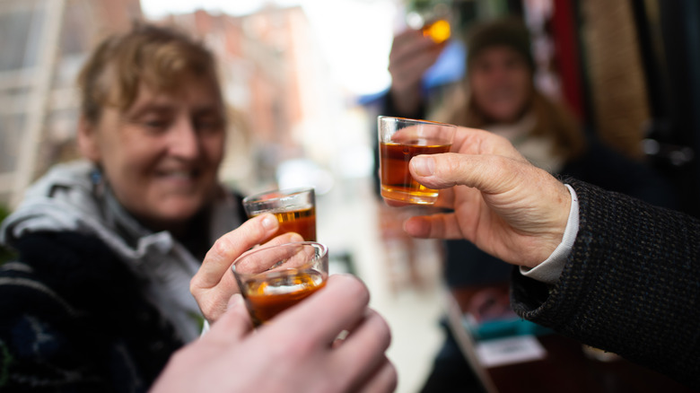 People making toast with whiskey