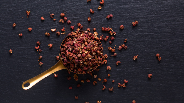 Hands holding Sichuan peppercorns