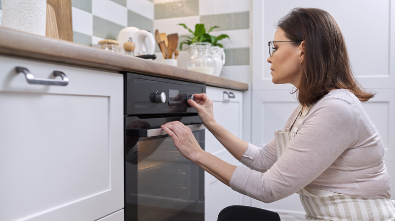 Woman turning on oven