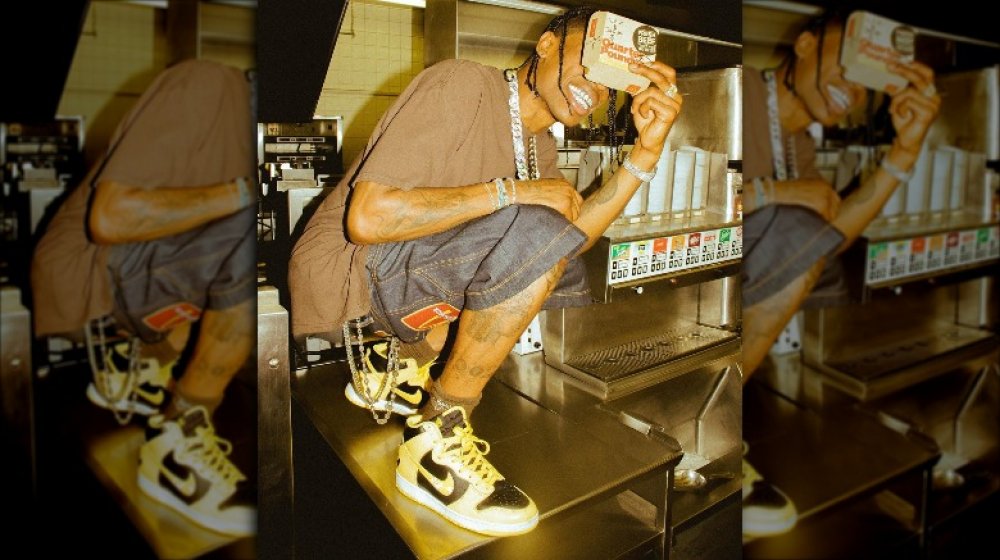 Travis Scott posing with Quarter Pounder box inside McDonald's