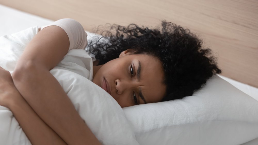 black woman unhappy laying in bed