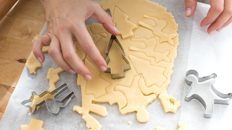 sugar cookie dough being cut into christmas shapes