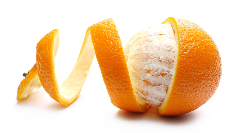 Half-peeled orange on white background