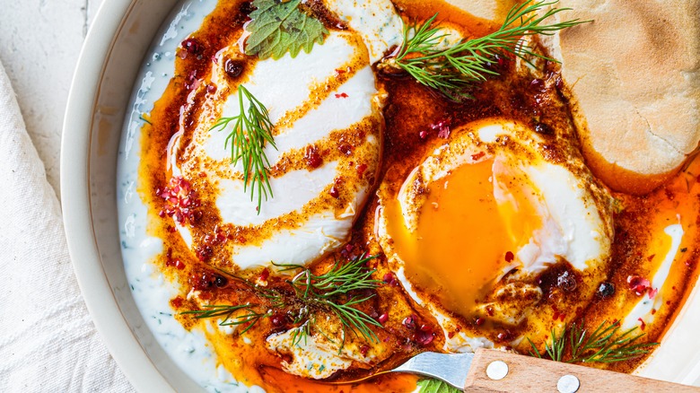 Fried eggs cooked in flavored oil with bread and herbs