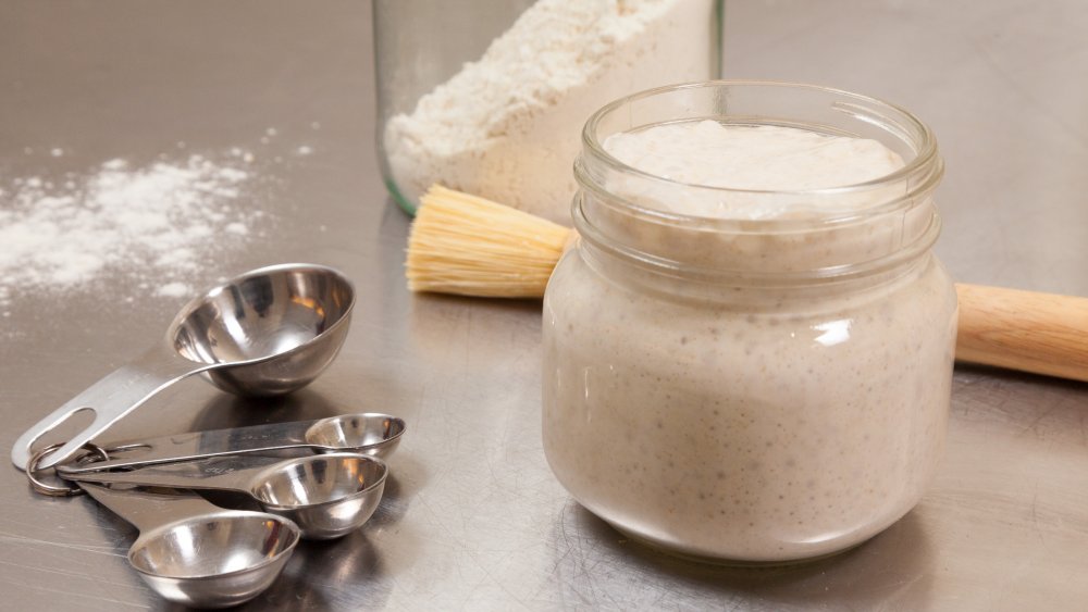 Sourdough starter with flour and measuring spoons