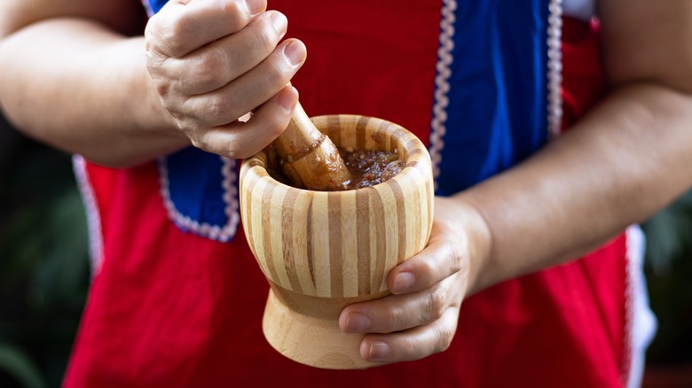 woman pestling red pepper paste